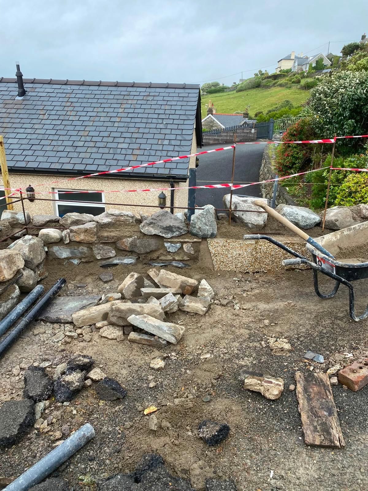 Ground preparation before stone wall construction in Caernarfon
